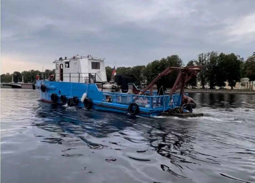 Буксир ведёт технический понтон вдоль набережной